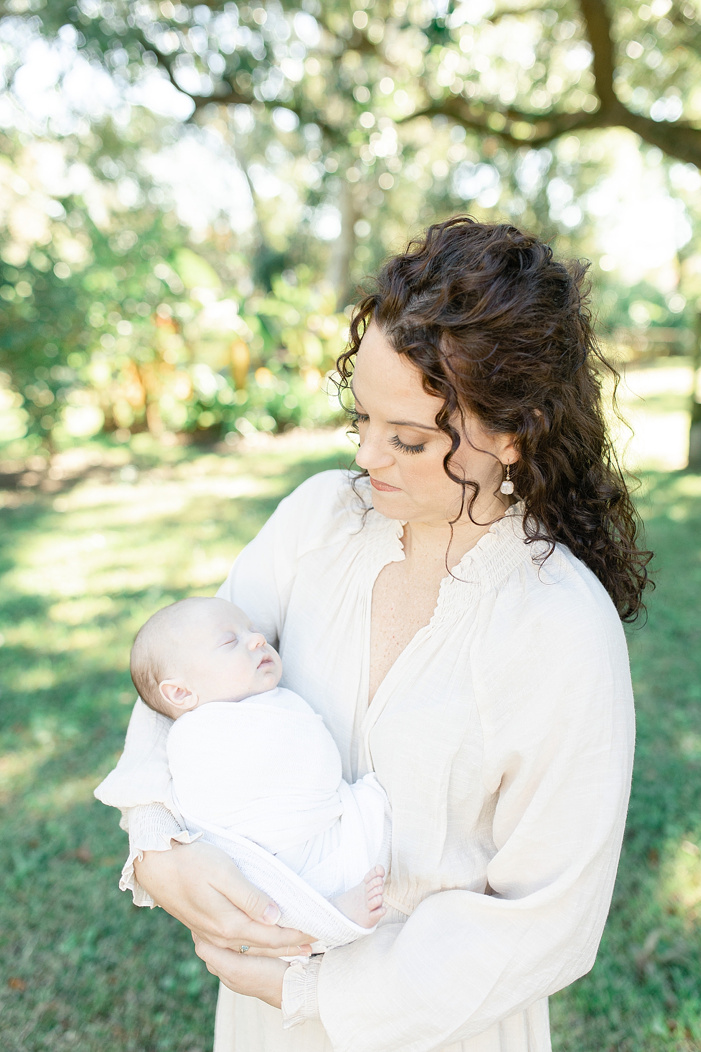 Mom in cream holding her newborn baby | Photo by Pascagoula NB photographer Little Sunshine Photography