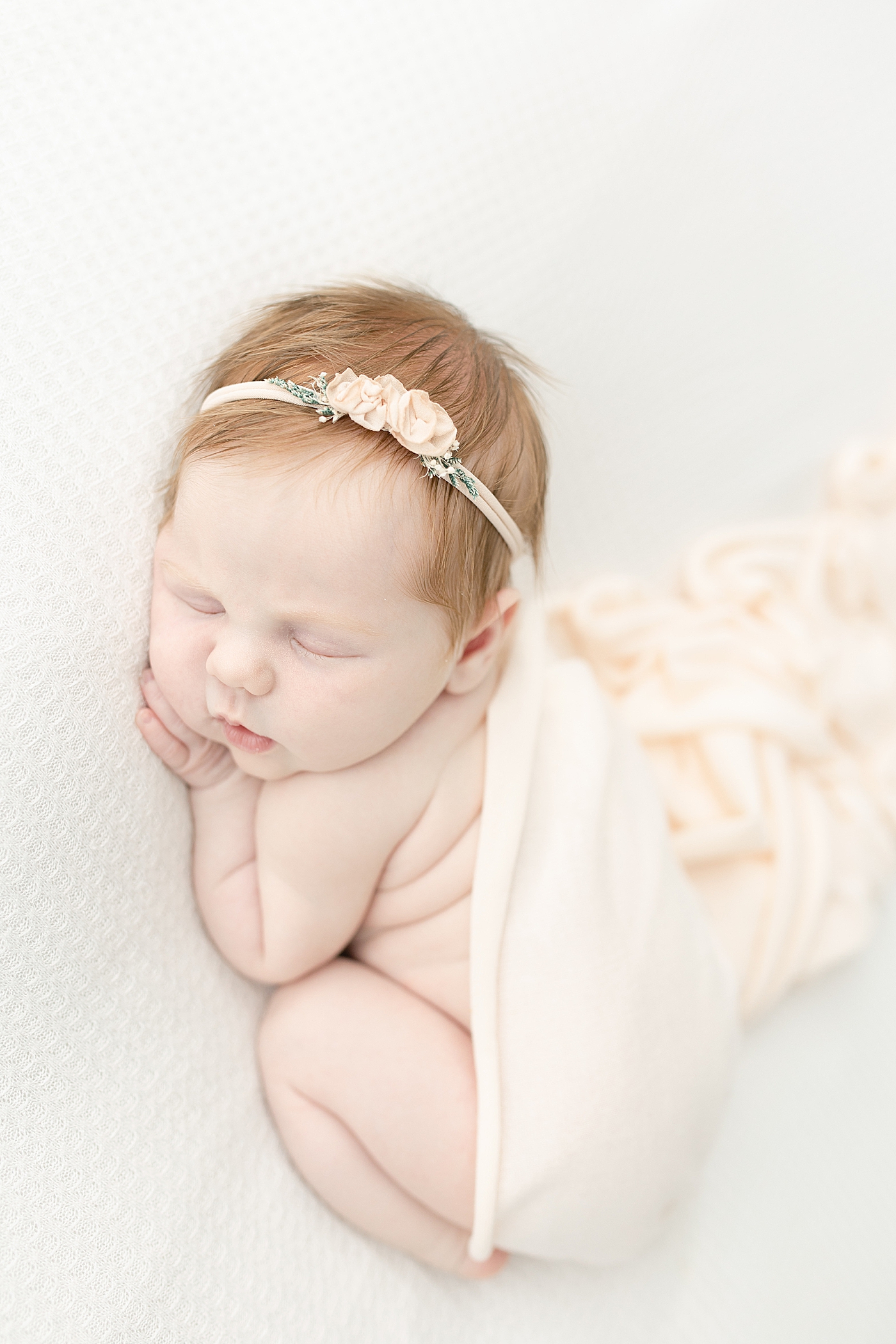 Sleeping baby girl in pink swaddle and headband | Photo by Little Sunshine Photography