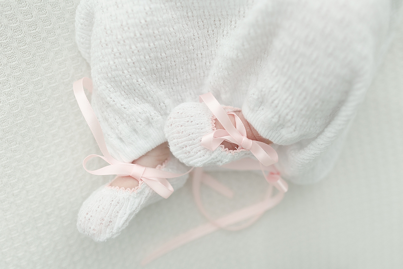 Detail of baby feet in crochet set with pink bows | Photo by Little Sunshine Photography