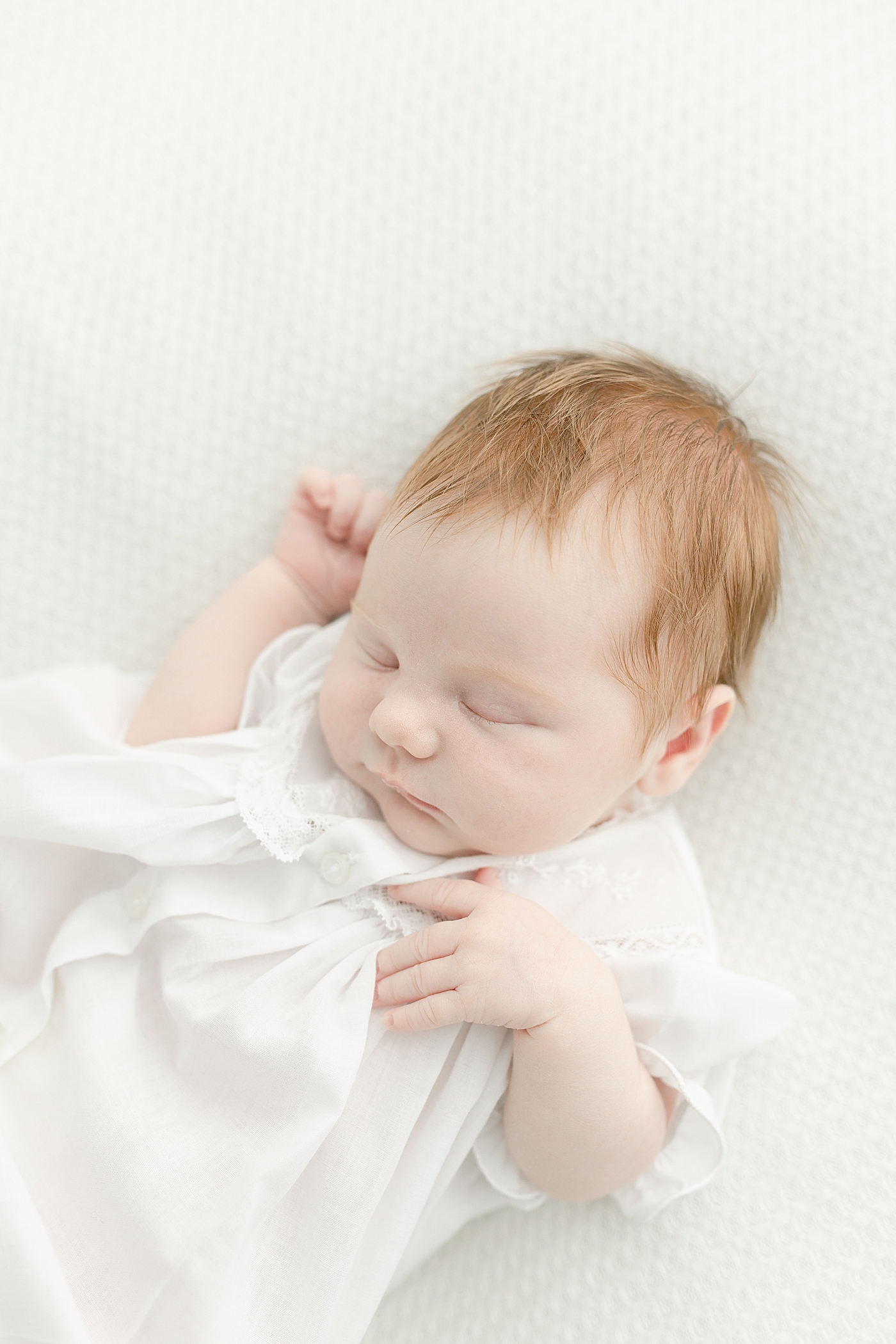 Sleeping newborn baby girl in white dress | Photo by Little Sunshine Photography