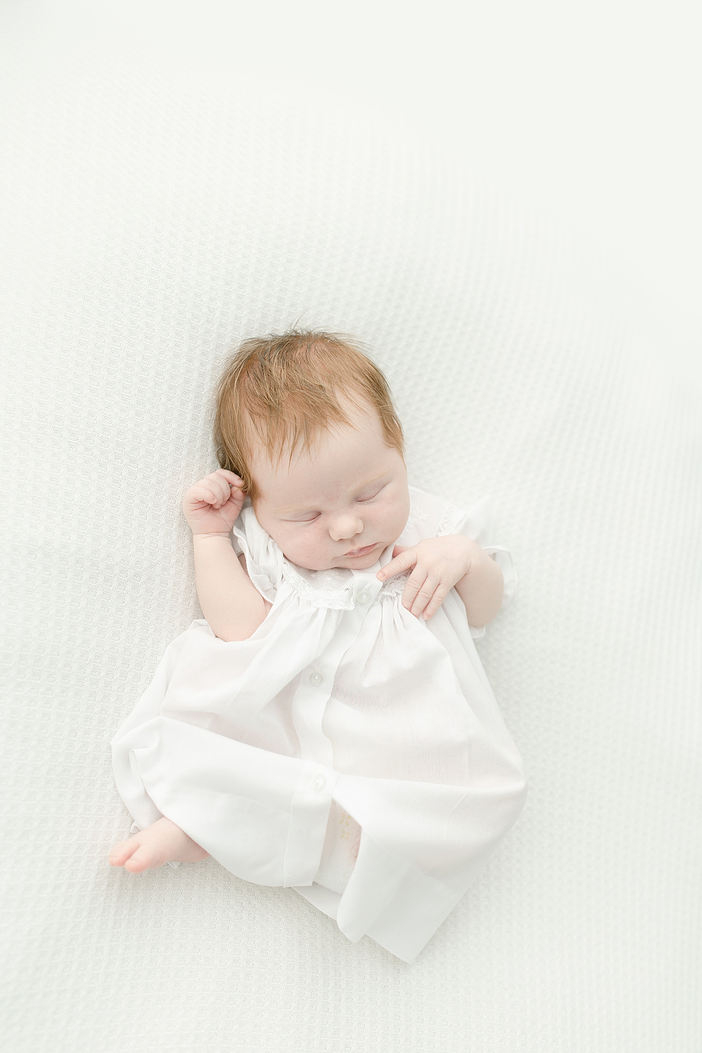 Newborn baby girl in white dress | Photo by Little Sunshine Photography