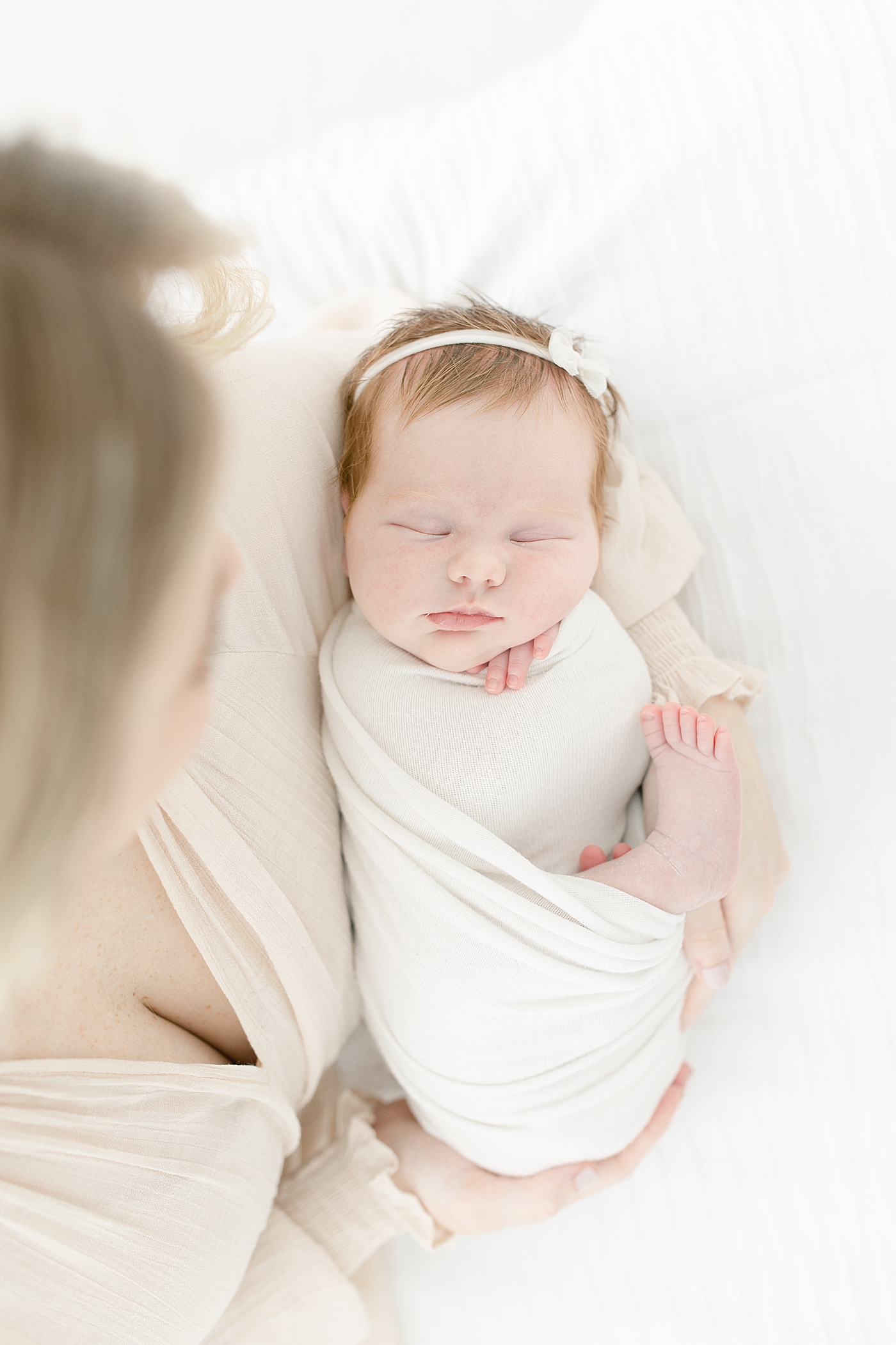 Baby girl swaddled in white wrap | Photo by Little Sunshine Photography