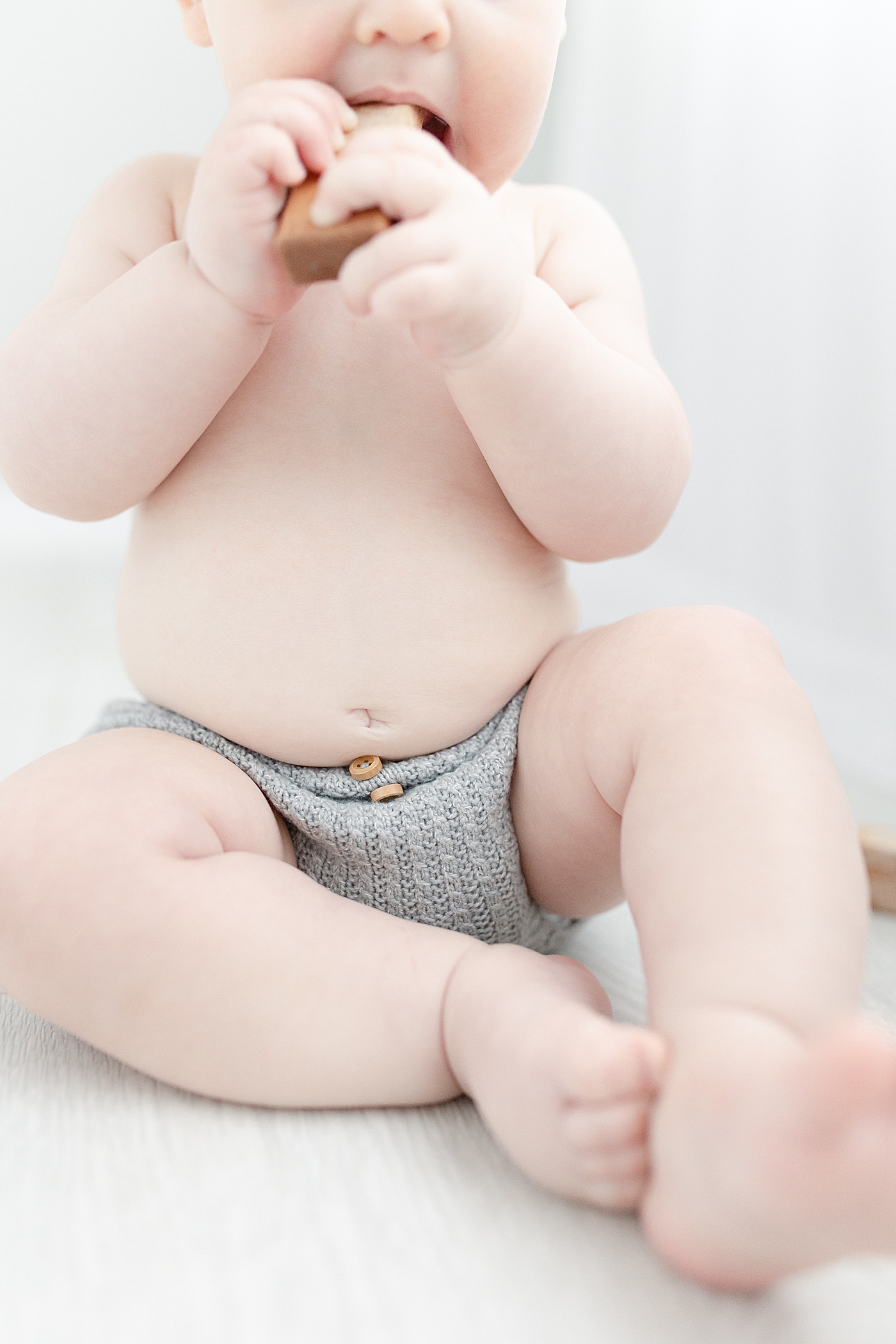 Baby boy in bloomers chewing on wooden blocks | Photo by Hattiesburg Baby Photographer Little Sunshine Photography