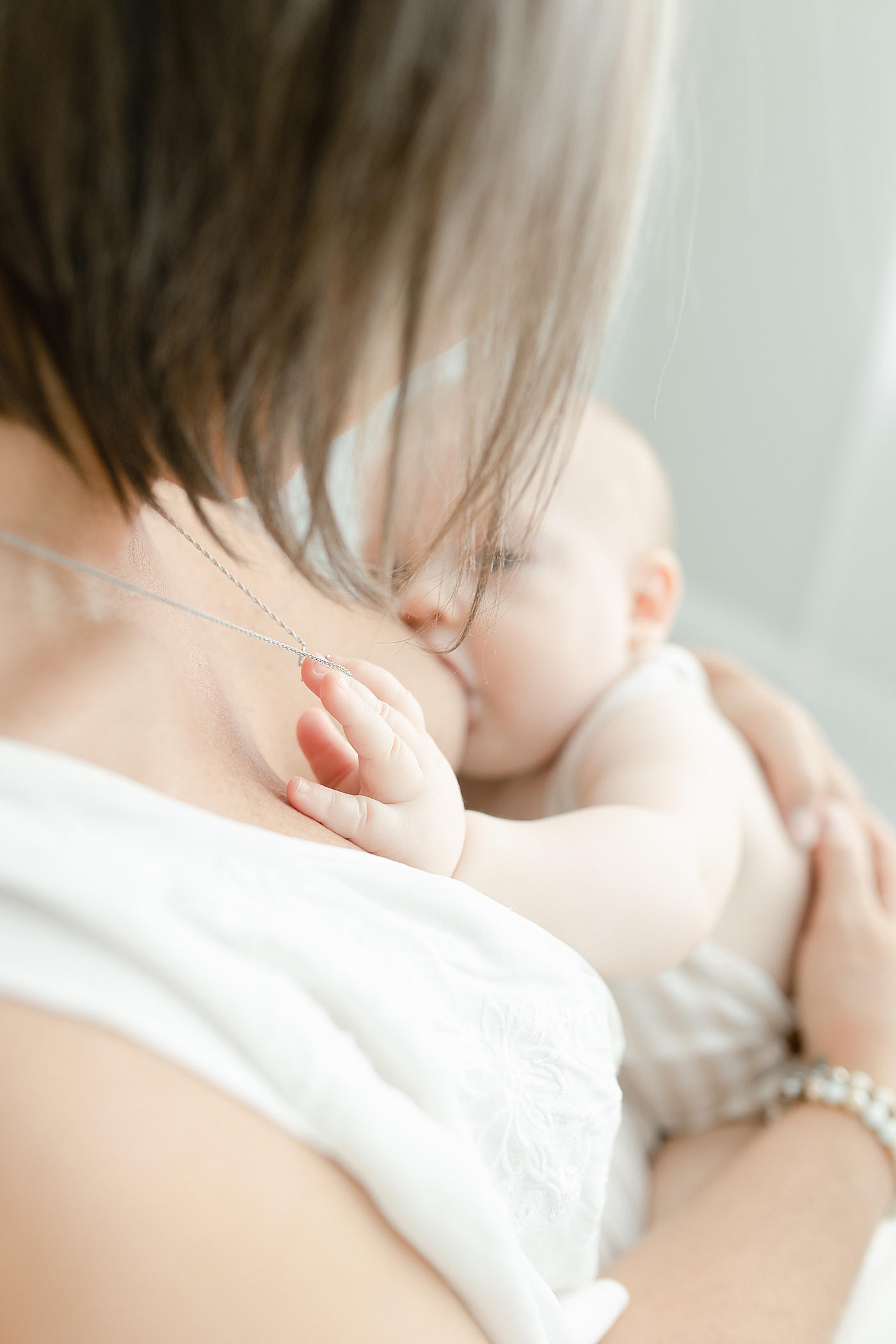 Baby holding mom's necklace while he nurses | Photo by Hattiesburg Baby Photographer Little Sunshine Photography