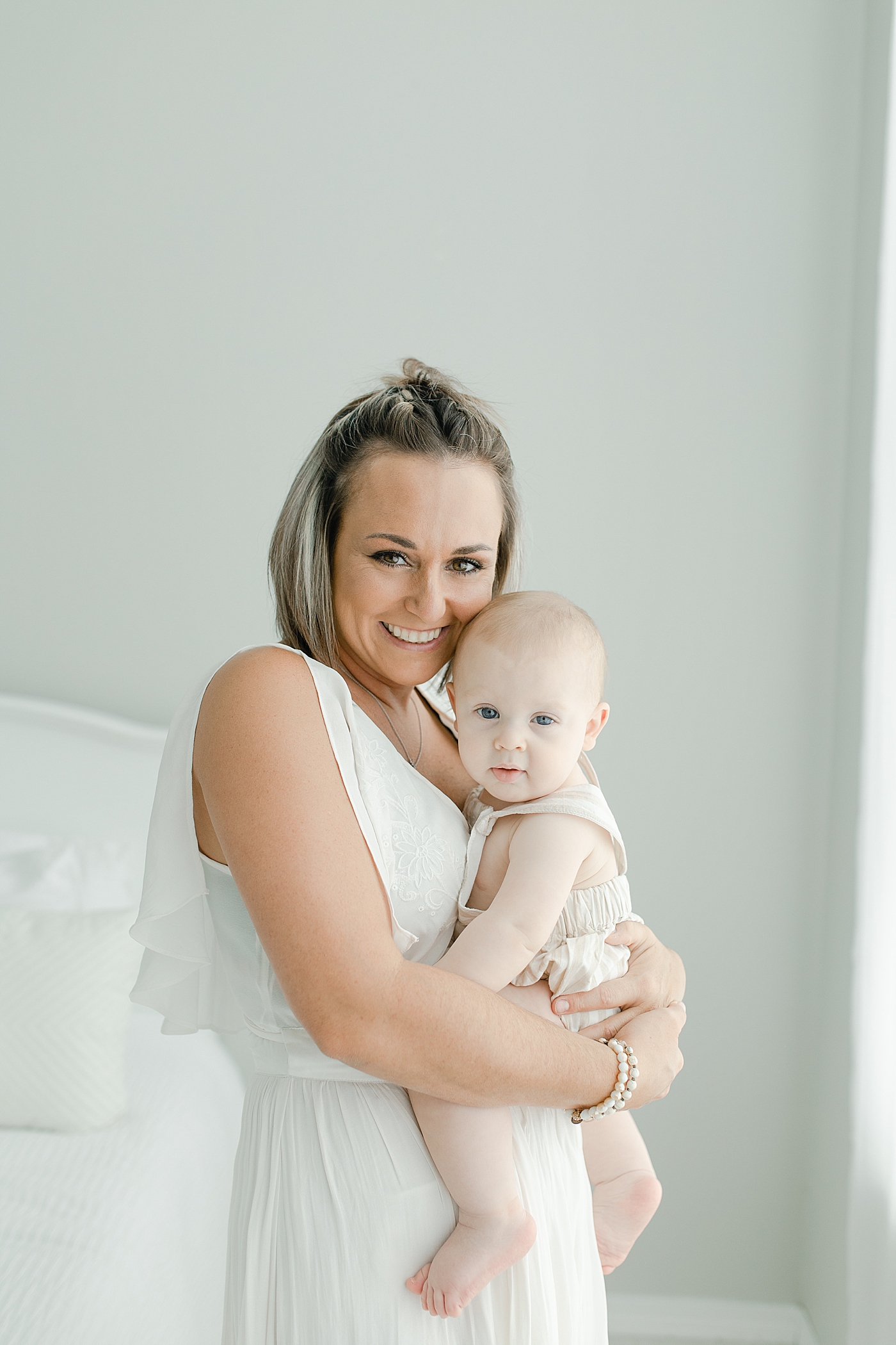 Mom in white dress snuggling with her baby boy | Photo by Hattiesburg Baby Photographer Little Sunshine Photography