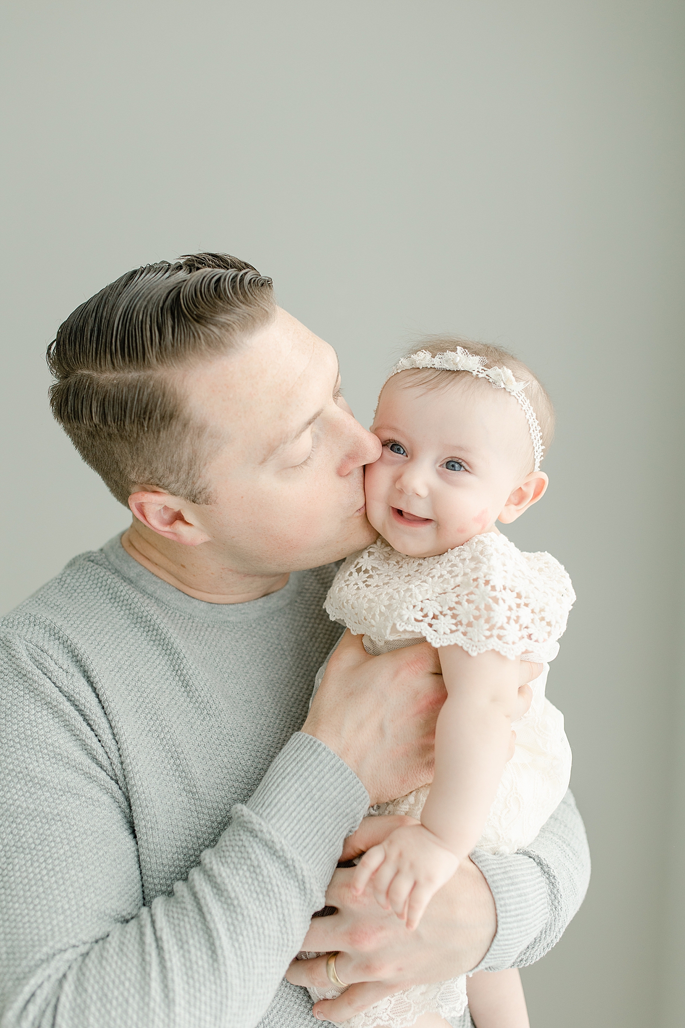 Dad kissing his baby girl on the cheek | Photo by Little Sunshine Photography
