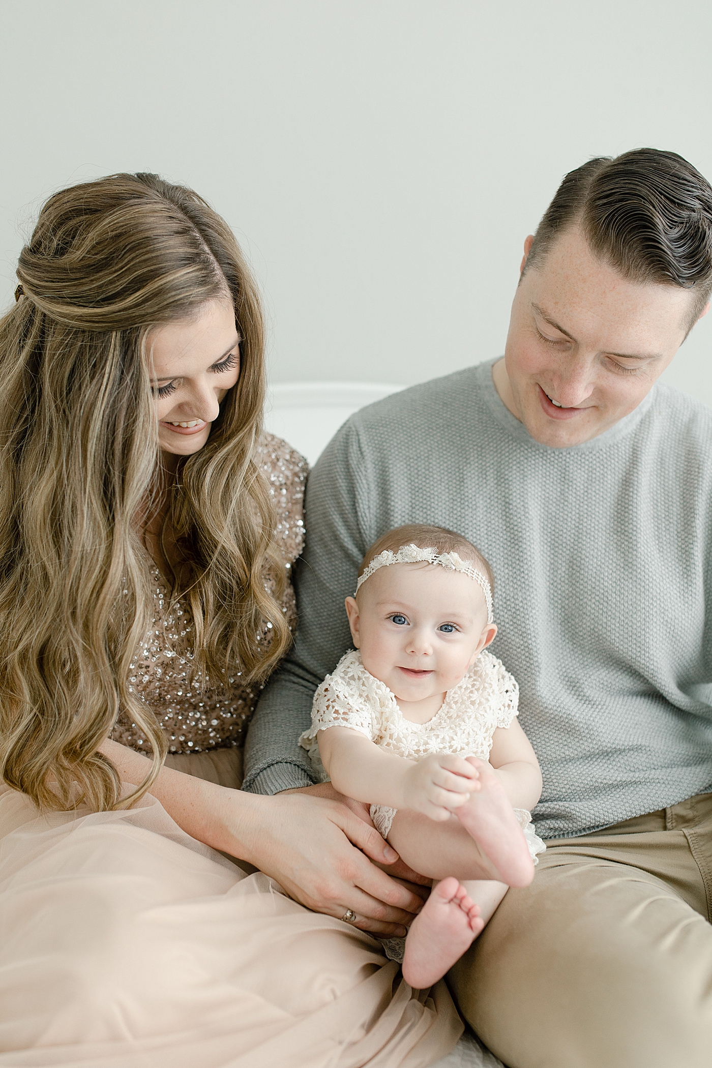 Mom and dad smiling with their baby girl for her sitter milestone session | Photo by Pass Christian baby photographer Little Sunshine Photography