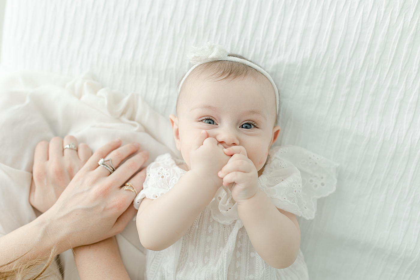 Baby girl chewing on her fingers | Photo by Little Sunshine Photography