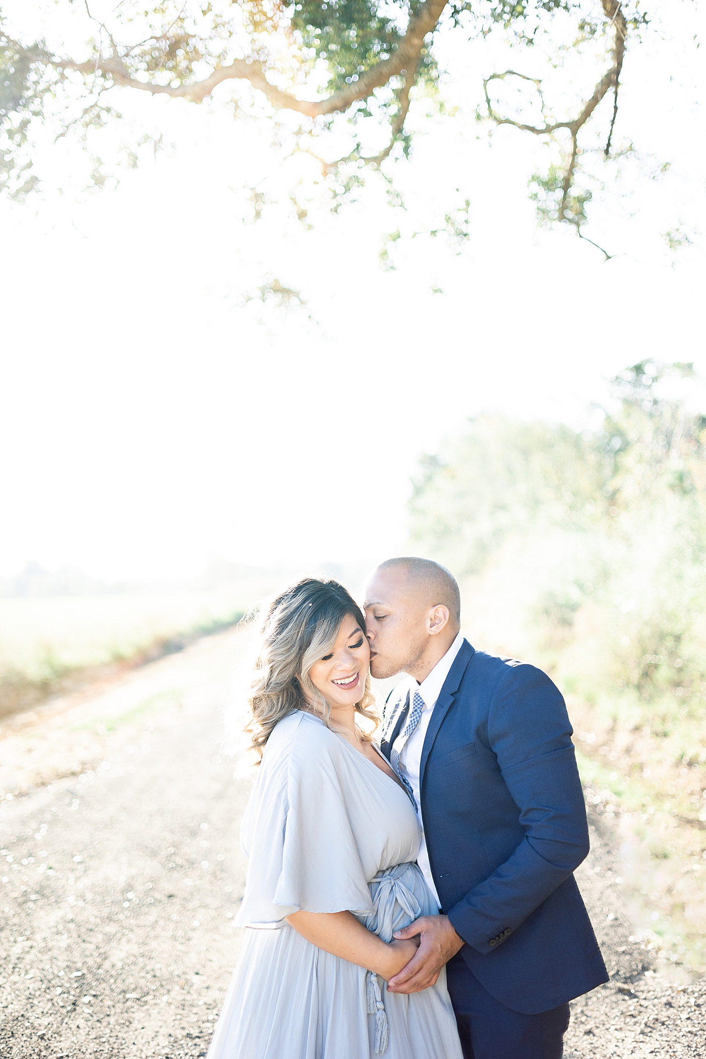 Dad to be kissing mom on the cheek | Photo by Little Sunshine Photography 