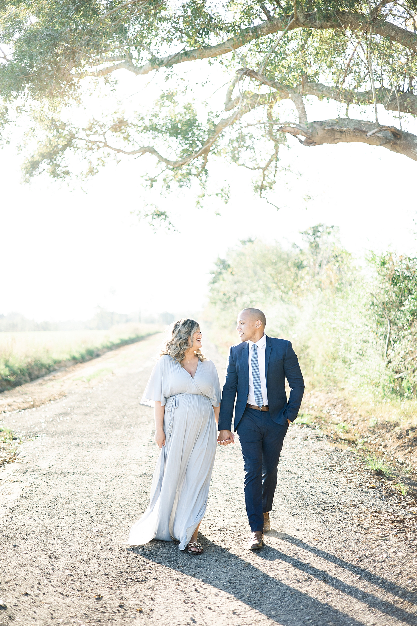 Mom and dad to be walking together down a path | Photo by Gulfport MS Maternity and Newborn Photographer Little Sunshine Photography 