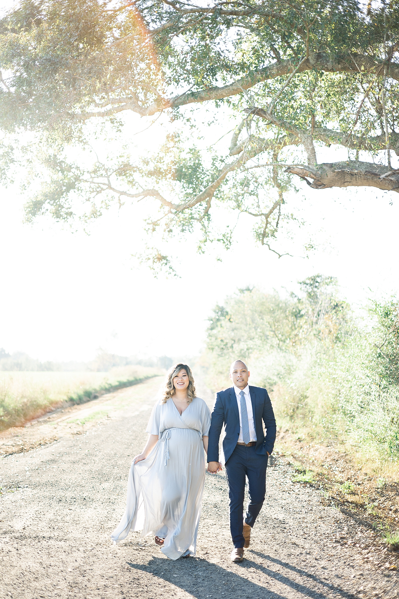 Mom and dad walking down a path holding hands | Photo by Gulfport MS Maternity and Newborn Photographer Little Sunshine Photography 