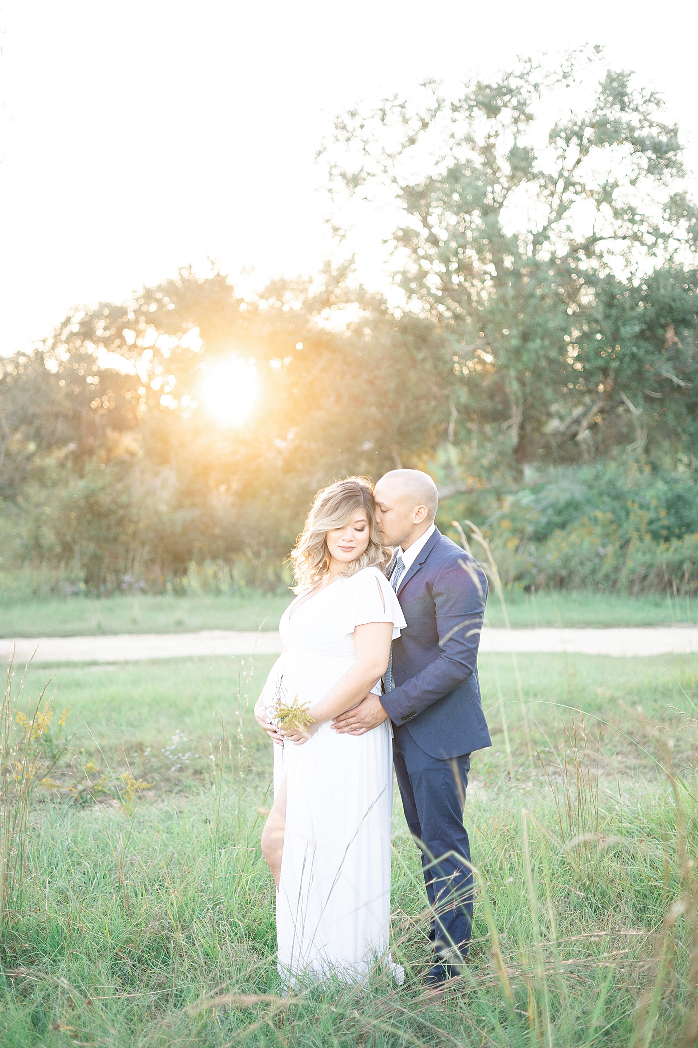 Mom and dad to be snuggling in a field at sunset | Photo by Gulfport MS Maternity and Newborn Photographer Little Sunshine Photography 