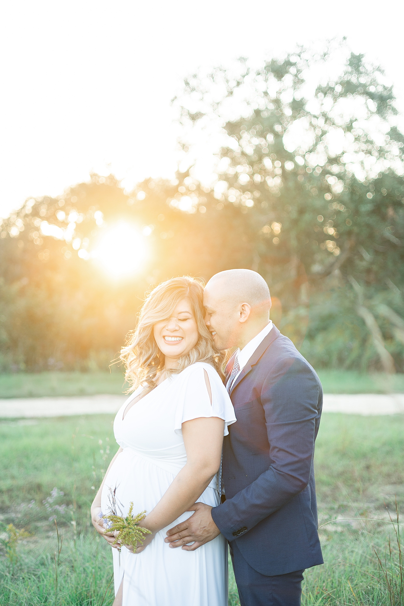 Mom and dad to be laughing together in a field | Photo by Gulfport MS Maternity and Newborn Photographer Little Sunshine Photography 