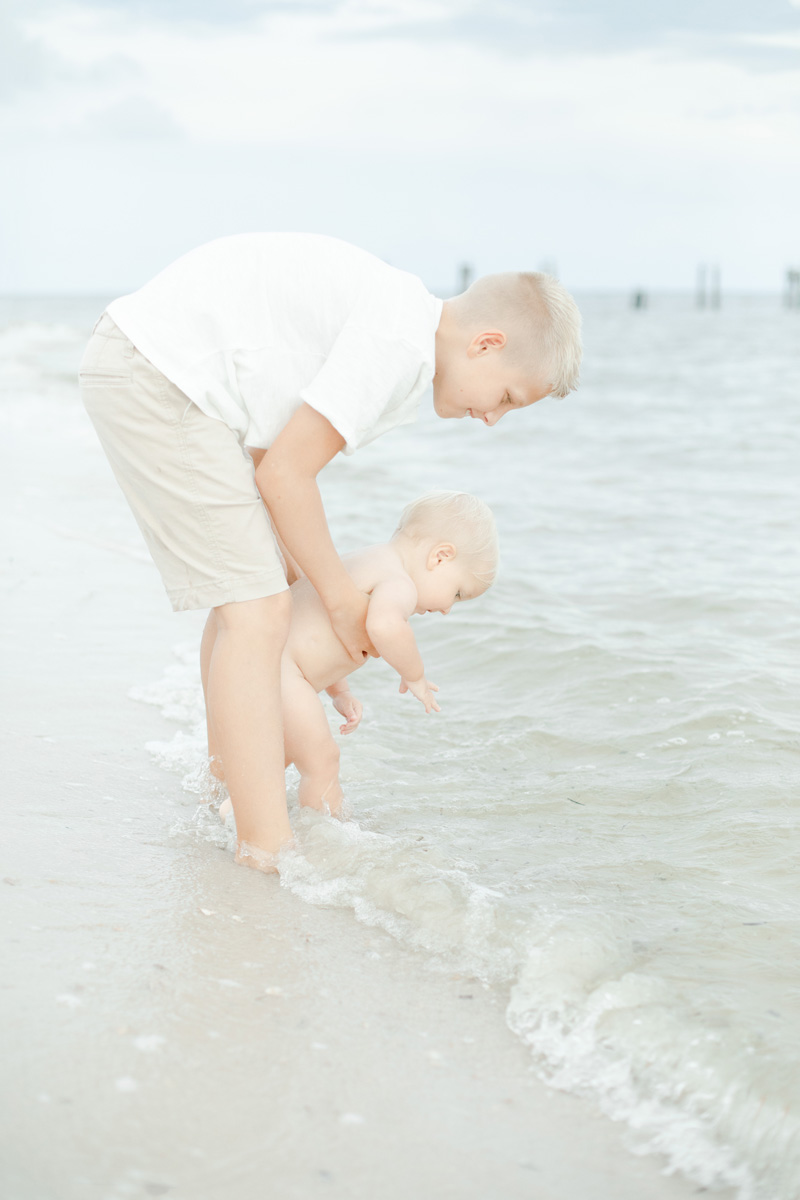 baby boy and big brother playing in water at beach photographer MS Gulf Coast